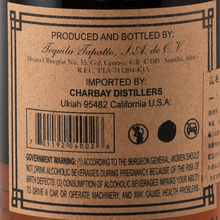 Load image into Gallery viewer, Close-up of a brown paper product label with black text, including 'Produced and Bottled by Tequila Tapatio, S.A.