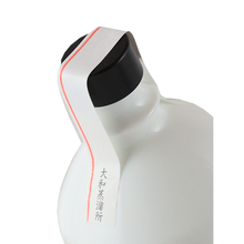 Load image into Gallery viewer, Kikka Gin Red Hanezu black cap, red-striped paper seal and white bottle shoulder, angled top view