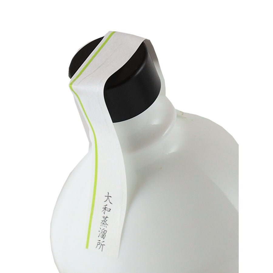 Kikka Gin Ruten black cap, green-striped paper seal and white bottle shoulder, angled top view